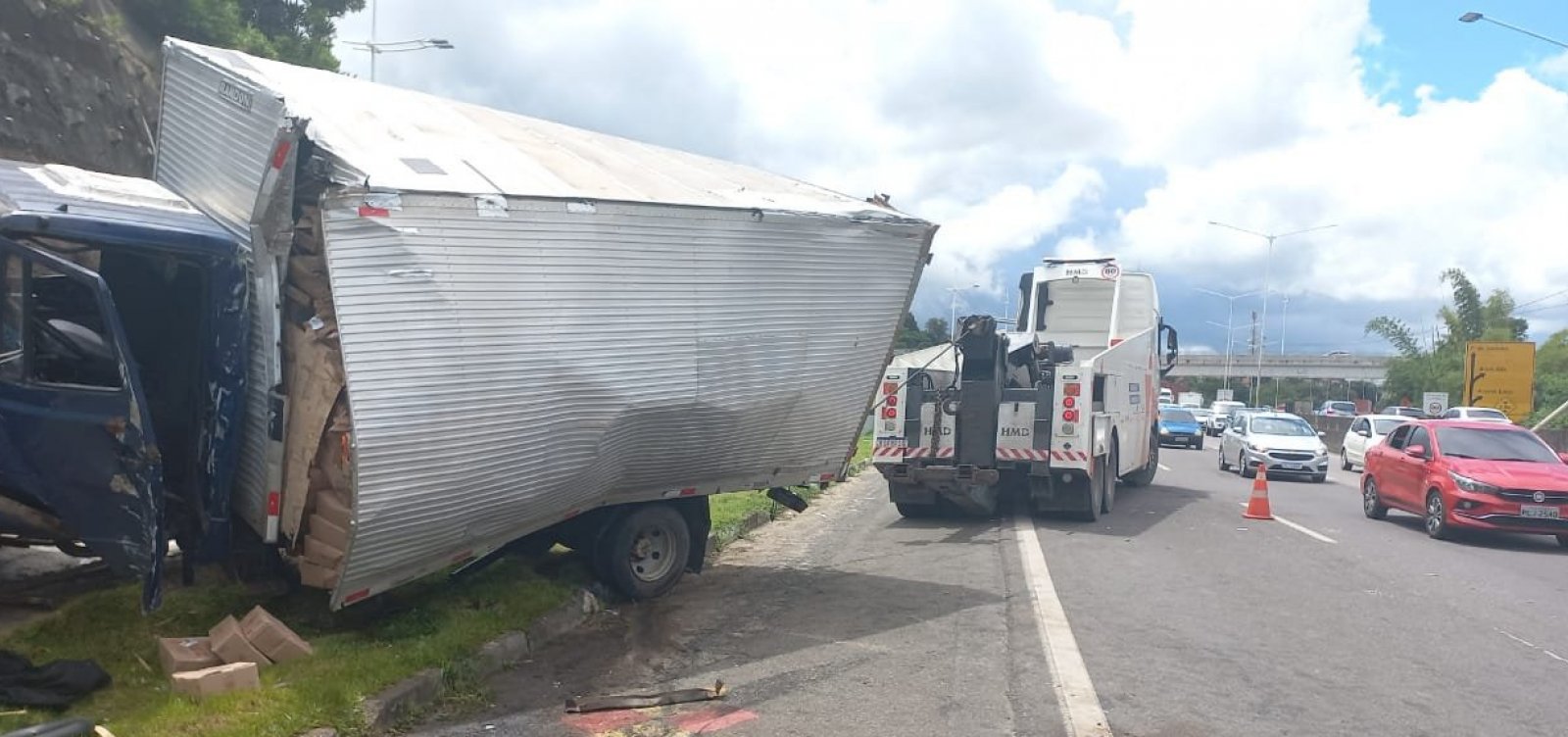 Caminhão com carga de chocolate perde controle na BR-324 após acidente entre carro e moto